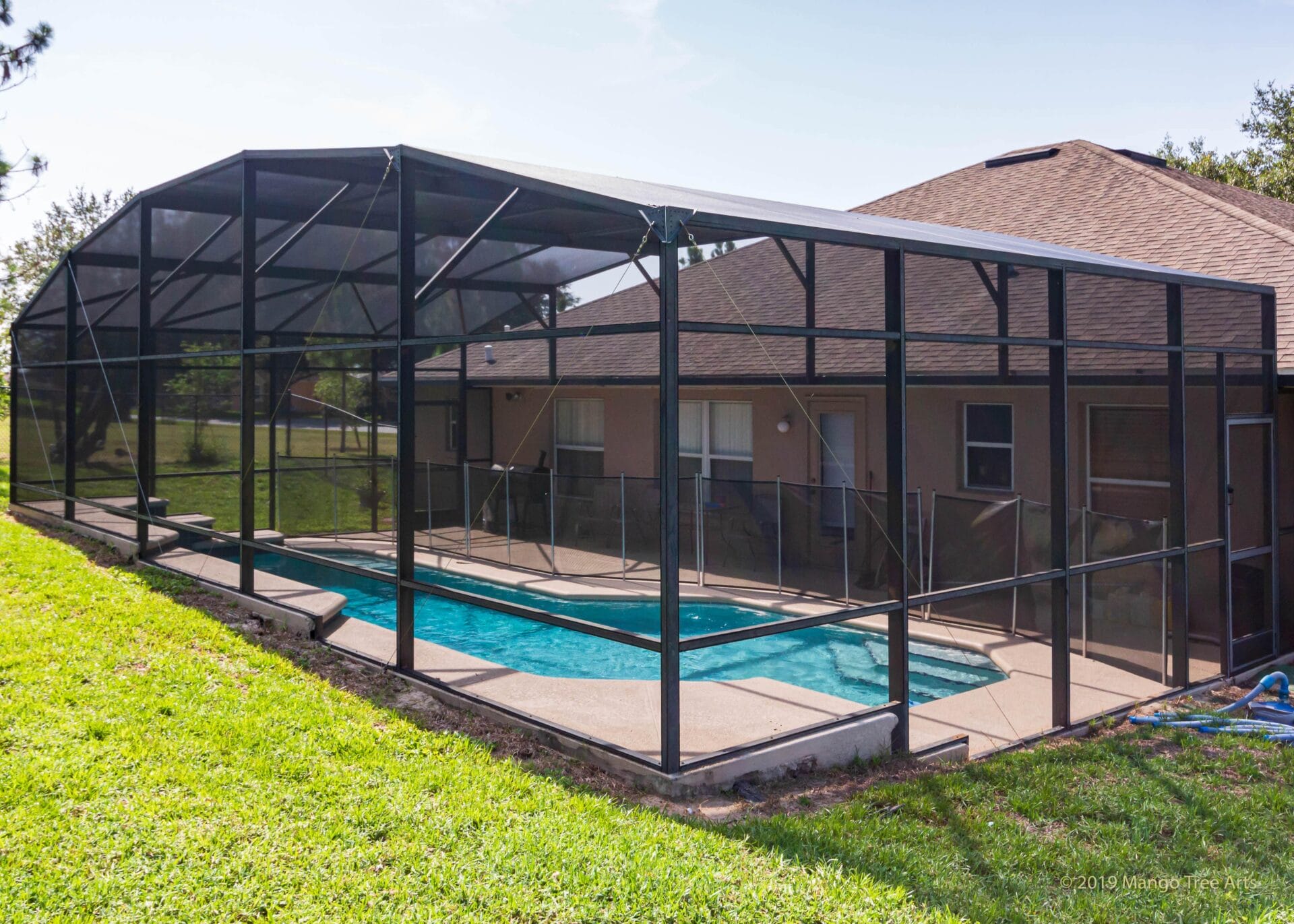 Black aluminum screen enclosure beside a Florida home